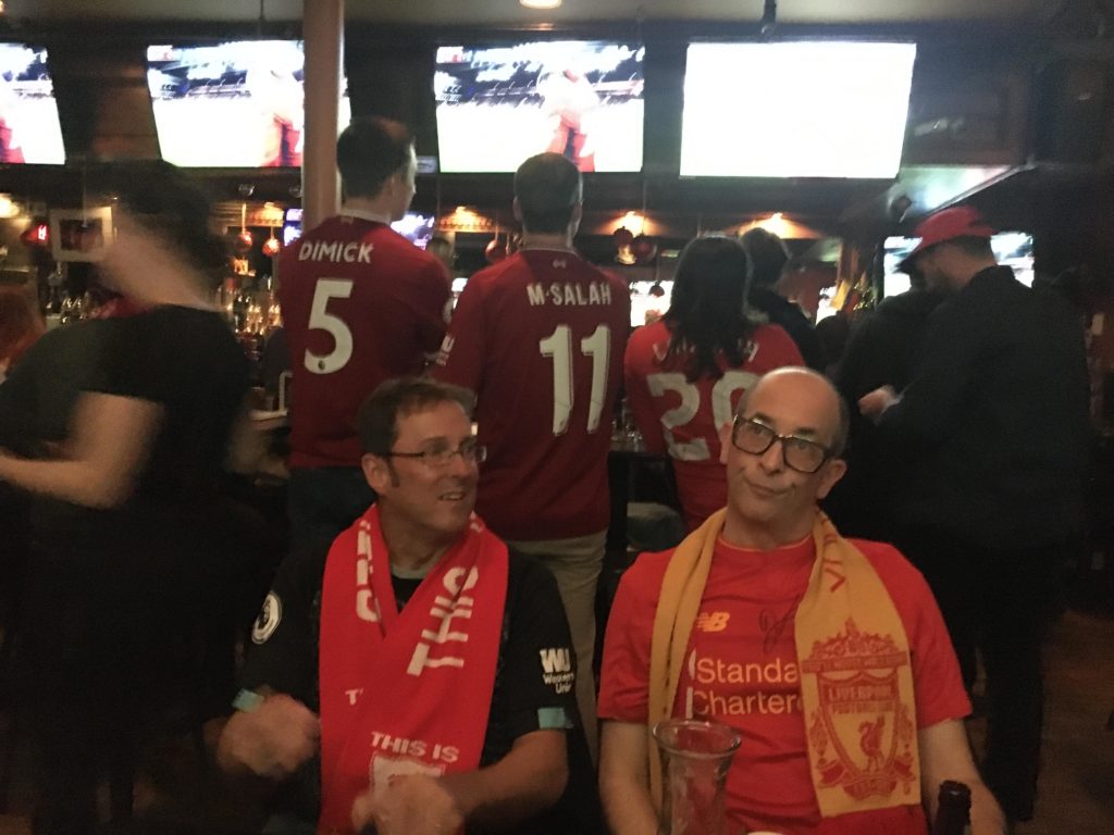 Author and guest at a bar watching soccer