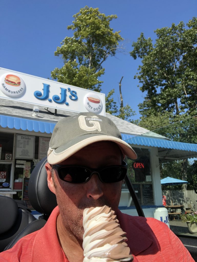 Man in baseball cap eating ice cream
