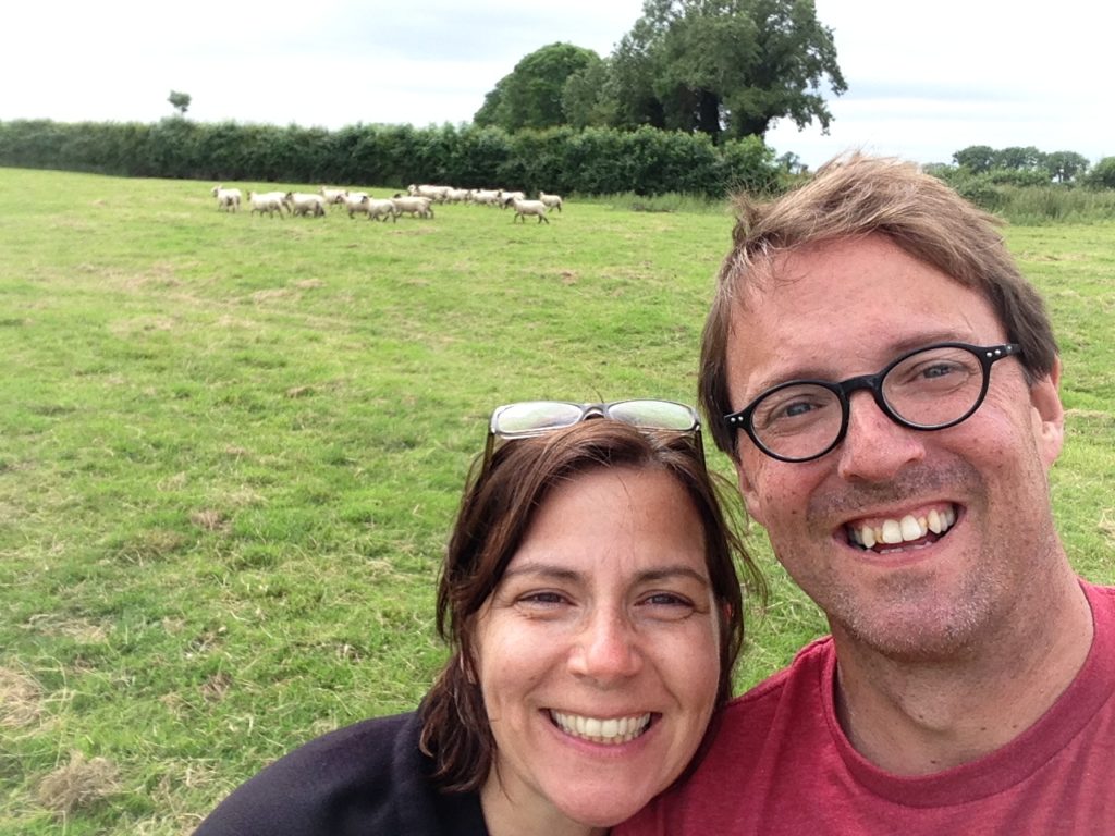 Two people in front of a field of sheep in Ireland