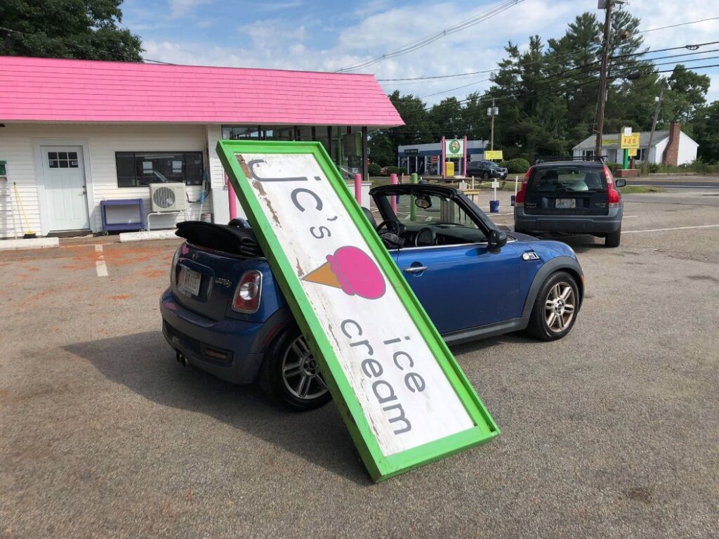 Sign leaning on a MINI Cooper Convertible